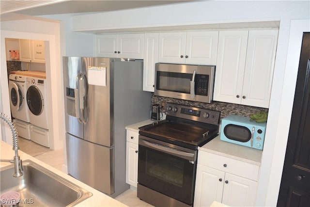 306 Pendleton Ave, Lehigh Acres, FL 33974 - kitchen featuring stainless steel appliances, separate washer and dryer, a sink, and white cabinets