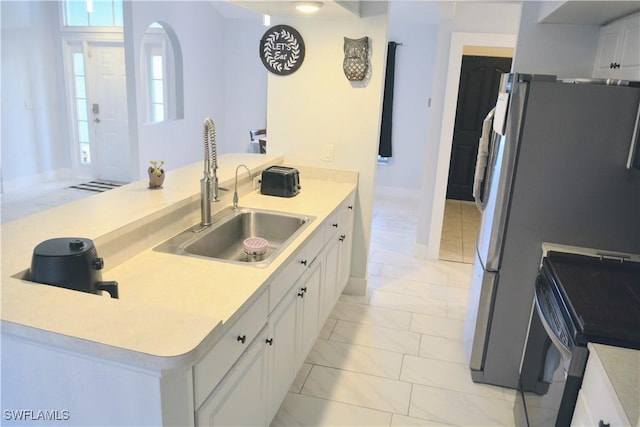 306 Pendleton Ave, Lehigh Acres, FL 33974 - kitchen with light marble finish floors, a sink, range with electric stovetop, a peninsula, and white cabinets
