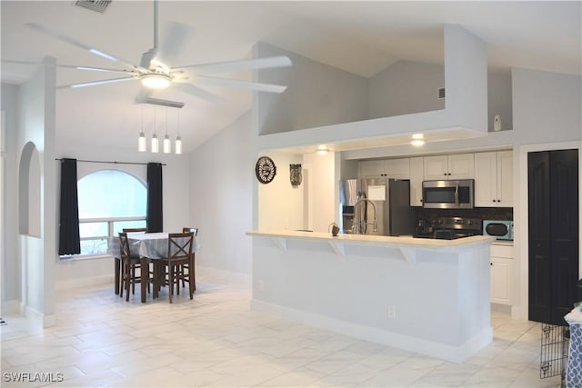 306 Pendleton Ave, Lehigh Acres, FL 33974 - kitchen with appliances with stainless steel finishes, high vaulted ceiling, ceiling fan, a breakfast bar, and a peninsula