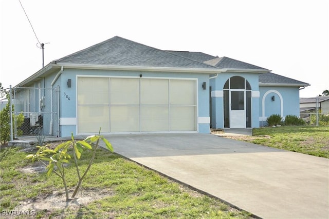 306 Pendleton Ave, Lehigh Acres, FL 33974 - ranch-style house with stucco siding, an attached garage, concrete driveway, and roof with shingles