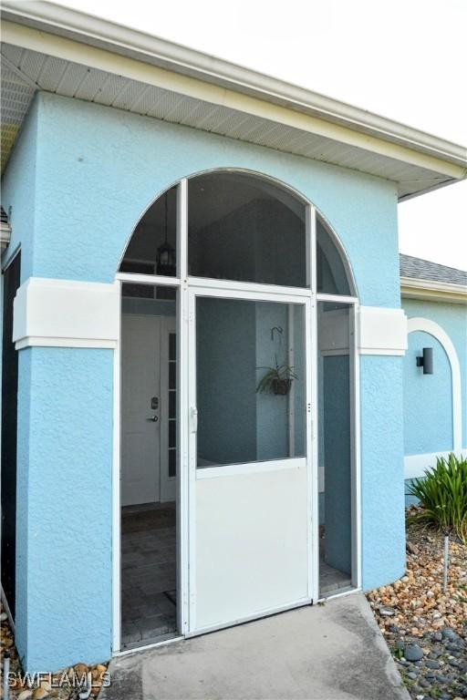 306 Pendleton Ave, Lehigh Acres, FL 33974 - view of exterior entry featuring stucco siding