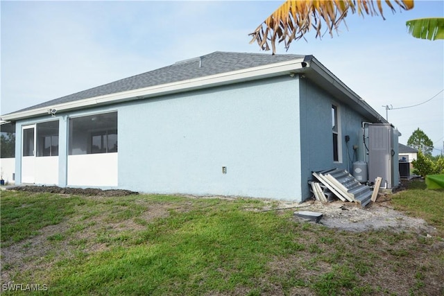 306 Pendleton Ave, Lehigh Acres, FL 33974 - view of side of home with stucco siding and a yard