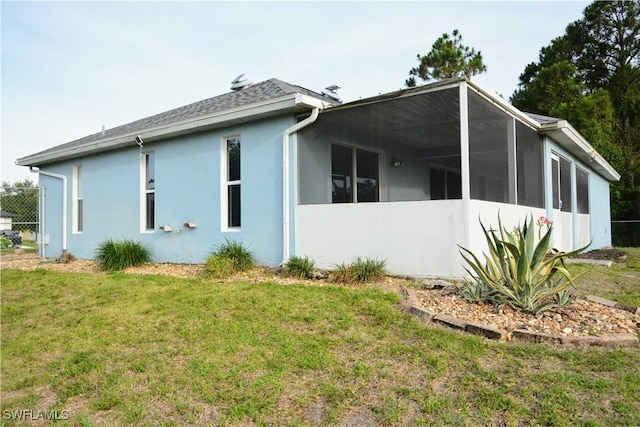 306 Pendleton Ave, Lehigh Acres, FL 33974 - view of side of home featuring a yard, stucco siding, and a shingled roof