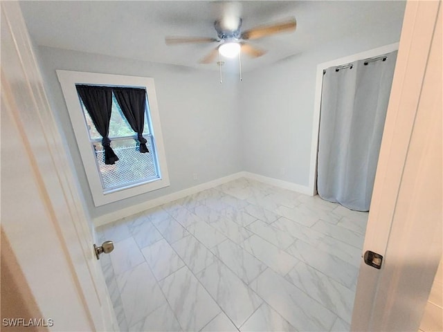 306 Pendleton Ave, Lehigh Acres, FL 33974 - spare room featuring light marble finish floors, ceiling fan, and baseboards