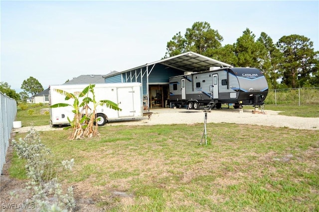 306 Pendleton Ave, Lehigh Acres, FL 33974 - rear view of house with a carport and driveway
