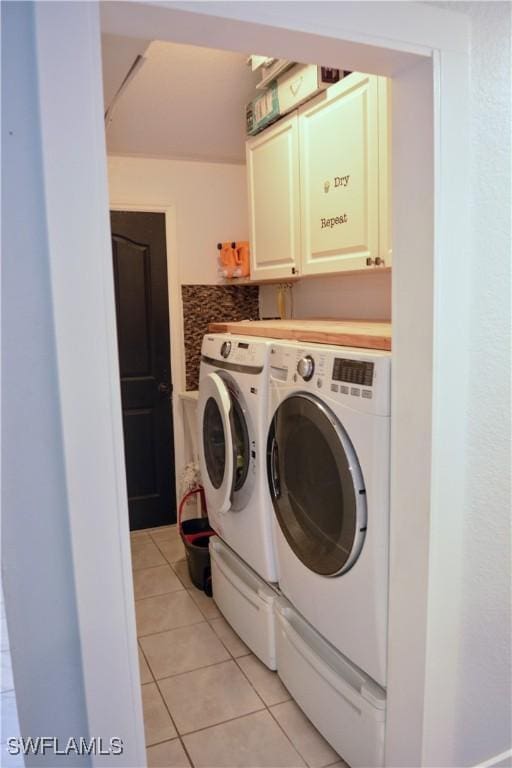 306 Pendleton Ave, Lehigh Acres, FL 33974 - laundry area featuring washing machine and clothes dryer, cabinet space, and light tile patterned floors
