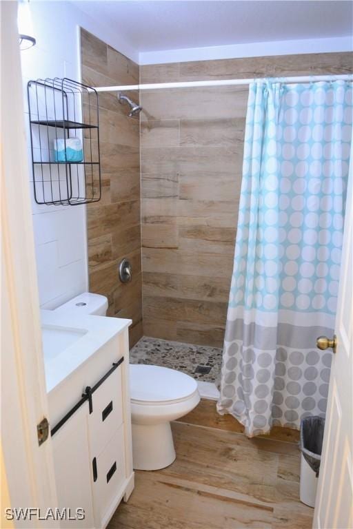 306 Pendleton Ave, Lehigh Acres, FL 33974 - bathroom featuring toilet, vanity, a tile shower, and wood finished floors