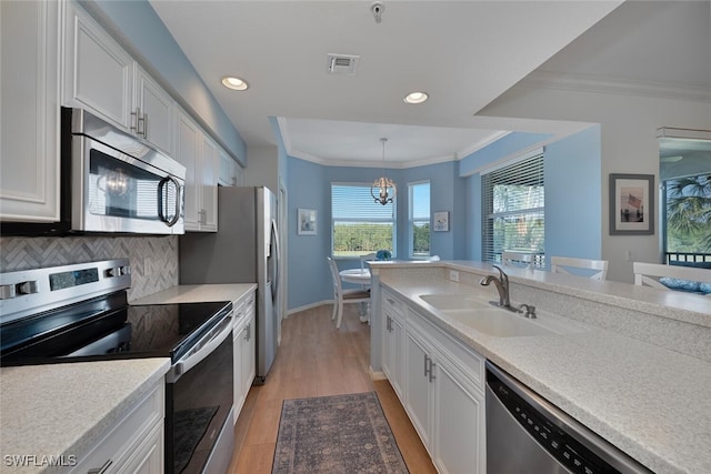 10275 Heritage Bay Blvd Unit 737, Naples, FL 34120 - kitchen with appliances with stainless steel finishes, a sink, white cabinets, recessed lighting, and light countertops