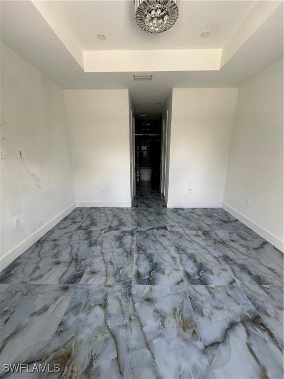 363 SW 24th Ct, Cape Coral, FL 33991 - unfurnished room with a raised ceiling, marble look tiles, and baseboards