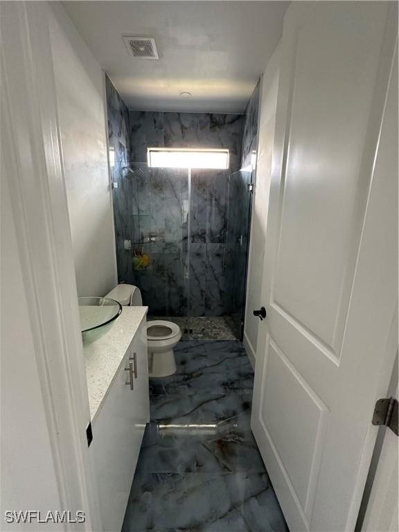 363 SW 24th Ct, Cape Coral, FL 33991 - bathroom with vanity, a marble finish shower, marble finish floors, and toilet