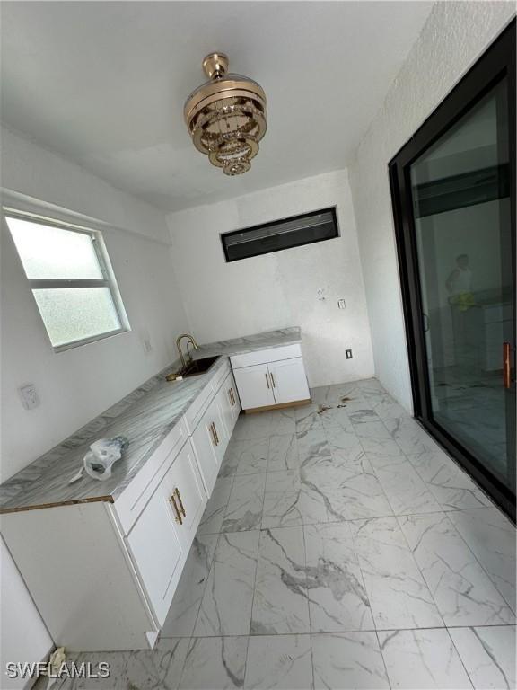 363 SW 24th Ct, Cape Coral, FL 33991 - bathroom with vanity, a stall shower, and marble look tiles