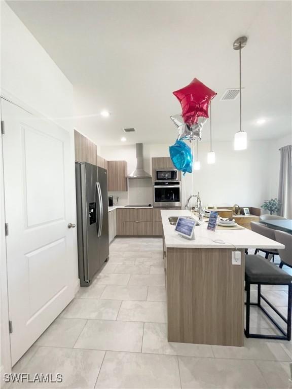 8016 Oakleaf Cir, Labelle, FL 33935 - kitchen featuring appliances with stainless steel finishes, a sink, modern cabinets, wall chimney range hood, and light countertops