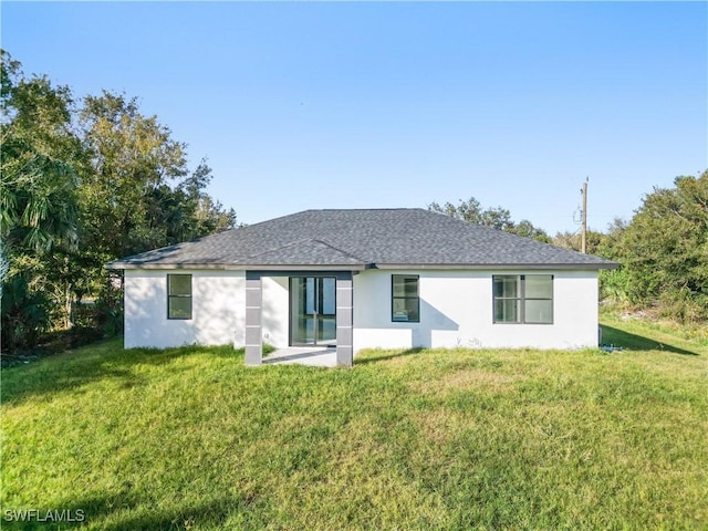 3313 66th St W, Lehigh Acres, FL 33971 - back of house featuring a lawn, stucco siding, and a shingled roof