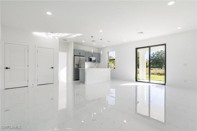 3313 66th St W, Lehigh Acres, FL 33971 - unfurnished living room with recessed lighting, light marble finish flooring, and a sink