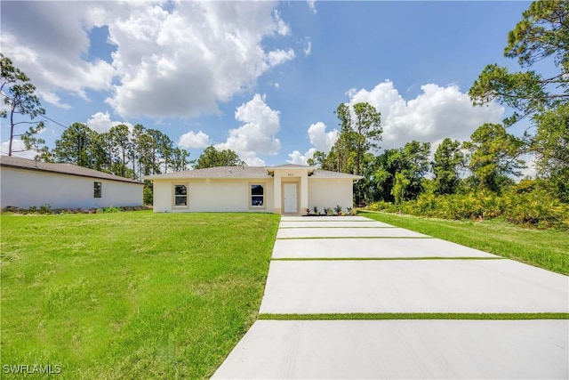 2511 45th St W, Lehigh Acres, FL 33971 - view of front of house with concrete driveway, a front yard, and stucco siding