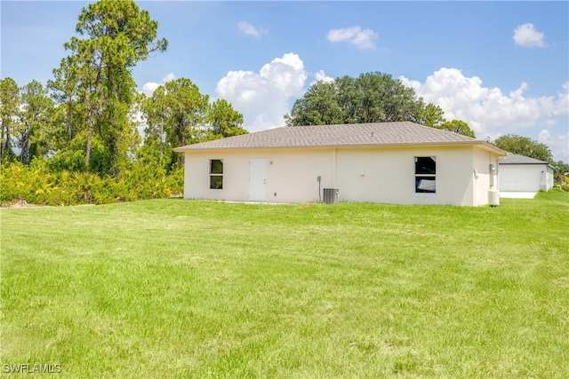 2511 45th St W, Lehigh Acres, FL 33971 - rear view of property featuring a yard, stucco siding, and central air condition unit