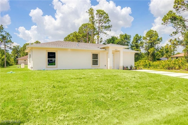 2511 45th St W, Lehigh Acres, FL 33971 - back of property with stucco siding and a lawn
