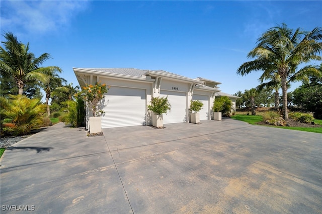 2405 SW 11th Ave, Cape Coral, FL 33991 - view of front of property with metal roof, concrete driveway, and stucco siding