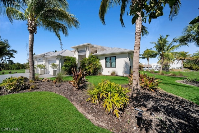 2405 SW 11th Ave, Cape Coral, FL 33991 - view of front of home with stucco siding, a front yard, and a garage