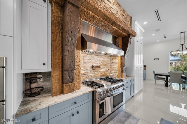 2405 SW 11th Ave, Cape Coral, FL 33991 - kitchen with range with two ovens, wall chimney range hood, backsplash, light tile patterned flooring, and light stone countertops