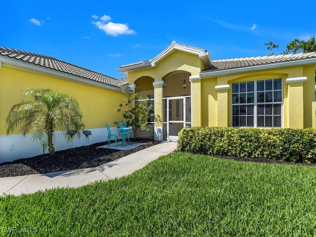 2040 Embarcadero Way N, Fort Myers, FL 33917 - entrance to property with a tile roof, a lawn, and stucco siding