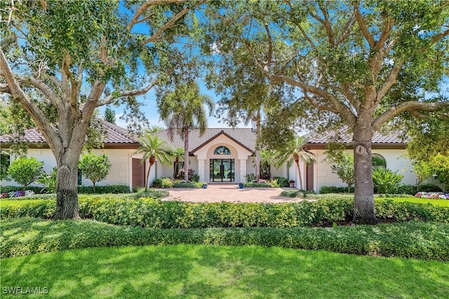 4701 Oak Leaf Dr, Naples, FL 34119 - mediterranean / spanish home featuring an attached garage, stucco siding, and a tiled roof
