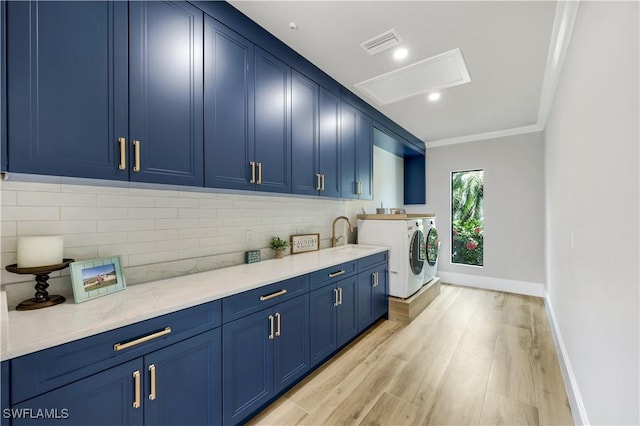 4701 Oak Leaf Dr, Naples, FL 34119 - kitchen with blue cabinets, separate washer and dryer, baseboards, a sink, and decorative backsplash