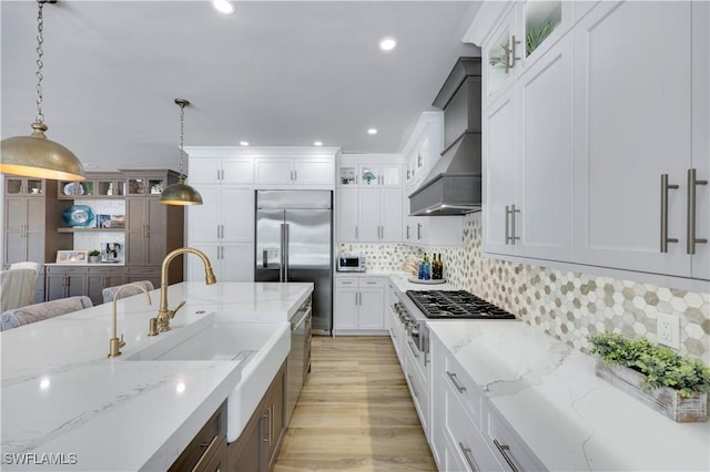 4701 Oak Leaf Dr, Naples, FL 34119 - kitchen featuring stainless steel appliances, custom range hood, a sink, white cabinets, and recessed lighting