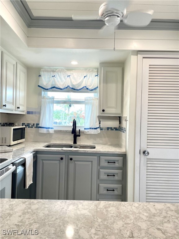 325 Charlemagne Blvd Unit B207, Naples, FL 34112 - kitchen featuring a sink, white microwave, backsplash, and a ceiling fan