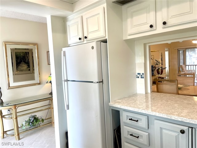 325 Charlemagne Blvd Unit B207, Naples, FL 34112 - kitchen with freestanding refrigerator, light countertops, and white cabinets