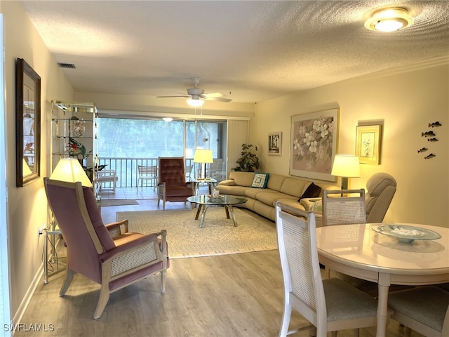 325 Charlemagne Blvd Unit B207, Naples, FL 34112 - living room featuring wood finished floors, ceiling fan, and a textured ceiling