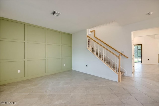 11260 Canopy Loop, Fort Myers, FL 33913 - unfurnished living room with a decorative wall, stairs, and tile patterned flooring