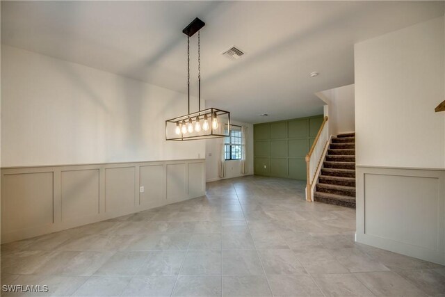 11260 Canopy Loop, Fort Myers, FL 33913 - empty room featuring a decorative wall, stairs, light tile patterned floors, and wainscoting