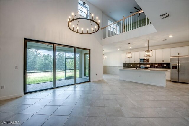 11260 Canopy Loop, Fort Myers, FL 33913 - unfurnished living room with a chandelier, a towering ceiling, light tile patterned flooring, baseboards, and recessed lighting