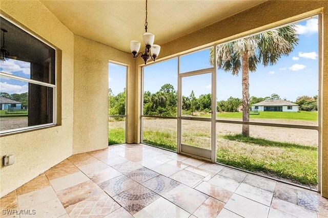 707 8th Ave, Lehigh Acres, FL 33972 - unfurnished sunroom featuring a chandelier