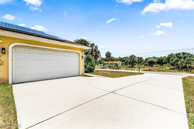 707 8th Ave, Lehigh Acres, FL 33972 - garage featuring solar panels and concrete driveway