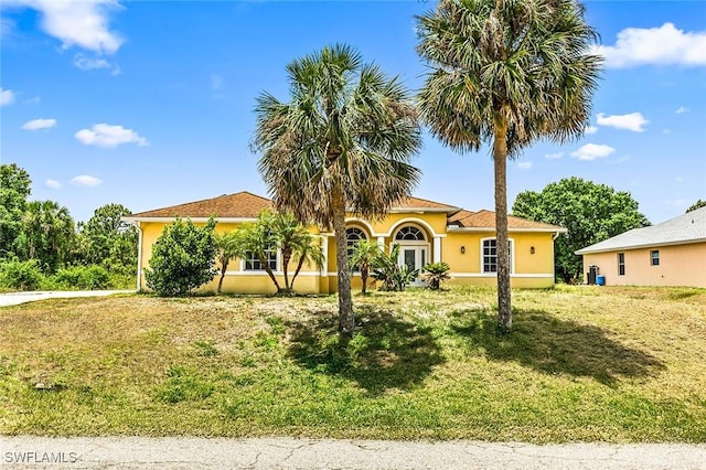 707 8th Ave, Lehigh Acres, FL 33972 - mediterranean / spanish-style house with a front lawn and stucco siding
