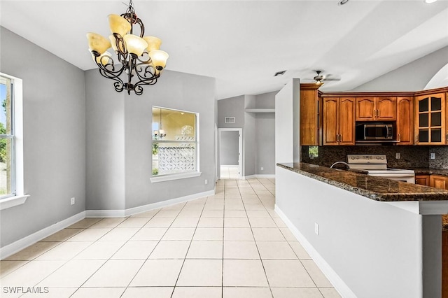 707 8th Ave, Lehigh Acres, FL 33972 - kitchen featuring electric stove, stainless steel microwave, brown cabinets, tasteful backsplash, and vaulted ceiling