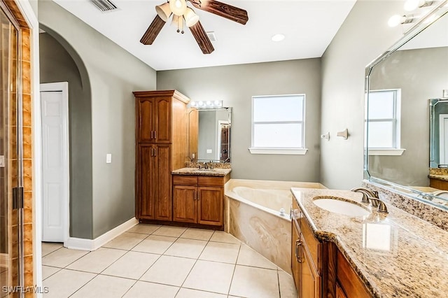 707 8th Ave, Lehigh Acres, FL 33972 - bathroom with a garden tub, two vanities, a ceiling fan, tile patterned floors, and a shower stall