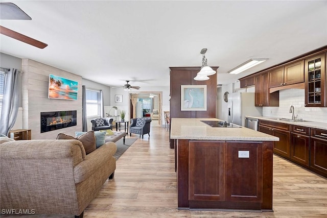 736 94th Ave N, Naples, FL 34108 - kitchen with ceiling fan, appliances with stainless steel finishes, a sink, a large fireplace, and open floor plan