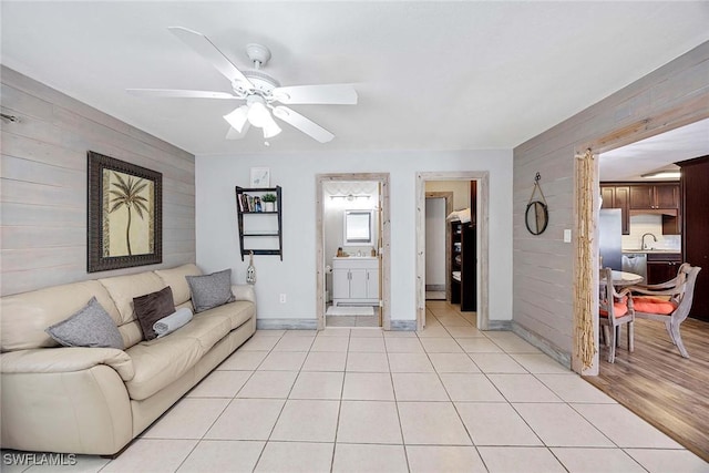 736 94th Ave N, Naples, FL 34108 - living room featuring wooden walls, ceiling fan, baseboards, and light tile patterned floors