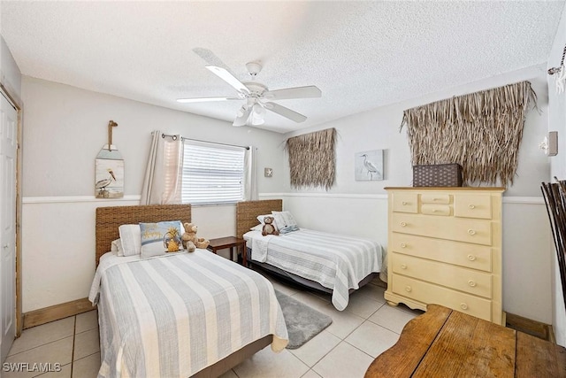 736 94th Ave N, Naples, FL 34108 - bedroom featuring light tile patterned floors, a textured ceiling, a ceiling fan, and baseboards