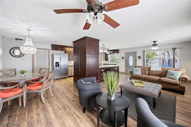 736 94th Ave N, Naples, FL 34108 - living room with a chandelier, healthy amount of natural light, a ceiling fan, and light wood-style floors