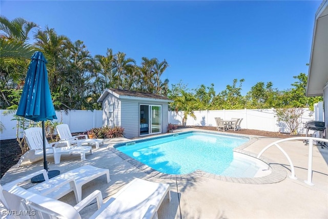668 94th Ave N, Naples, FL 34108 - view of swimming pool featuring a patio area, a fenced backyard, and an outbuilding