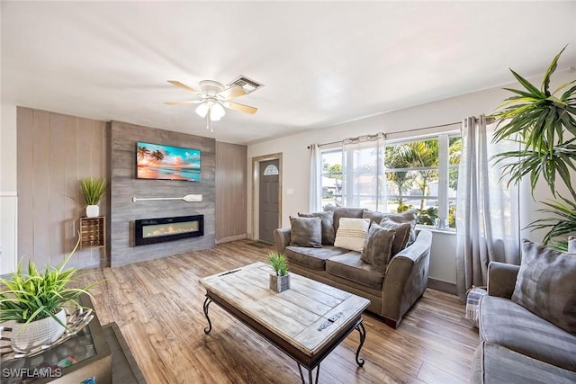 668 94th Ave N, Naples, FL 34108 - living area with a fireplace, a ceiling fan, light wood-type flooring, and baseboards