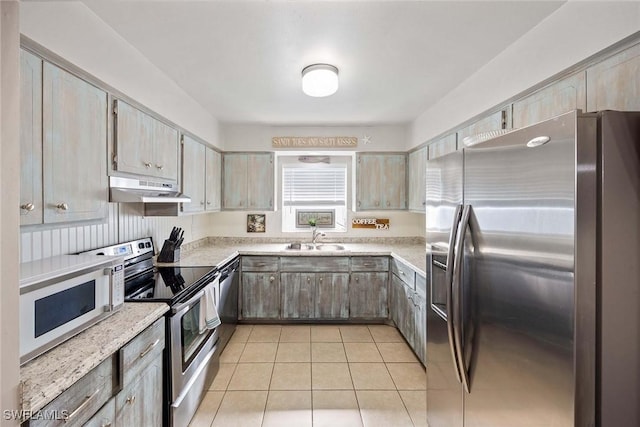 668 94th Ave N, Naples, FL 34108 - kitchen featuring stainless steel appliances, a sink, under cabinet range hood, light countertops, and light tile patterned flooring