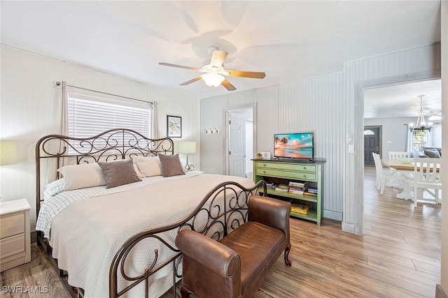 668 94th Ave N, Naples, FL 34108 - bedroom with light wood-style floors, a chandelier, and a ceiling fan
