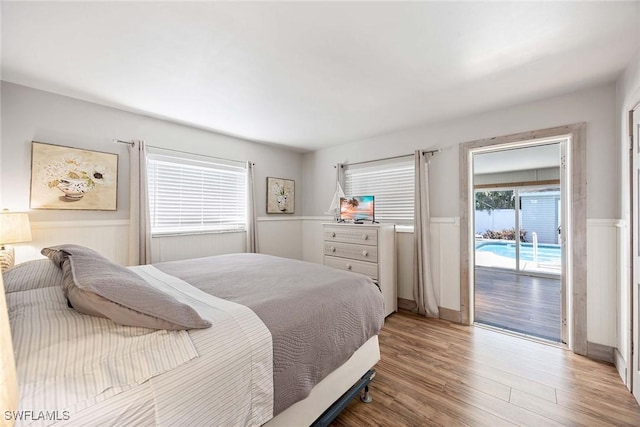 668 94th Ave N, Naples, FL 34108 - bedroom with access to exterior, a wainscoted wall, and wood finished floors