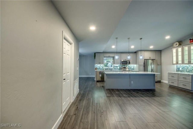 14160 Cedardale St, Fort Myers, FL 33905 - kitchen with stainless steel appliances, tasteful backsplash, a kitchen island, baseboards, and dark wood-style flooring