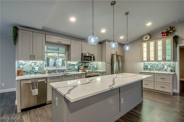 14160 Cedardale St, Fort Myers, FL 33905 - kitchen featuring appliances with stainless steel finishes, a kitchen island, decorative backsplash, a sink, and lofted ceiling